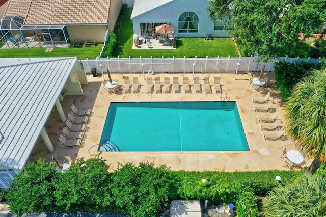 community pool featuring a patio area, fence, and a lawn