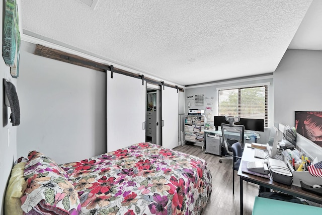 3750 NW 73rd Way, Coral Springs, FL 33065 - bedroom with a barn door, a textured ceiling, wood finished floors, and an office area