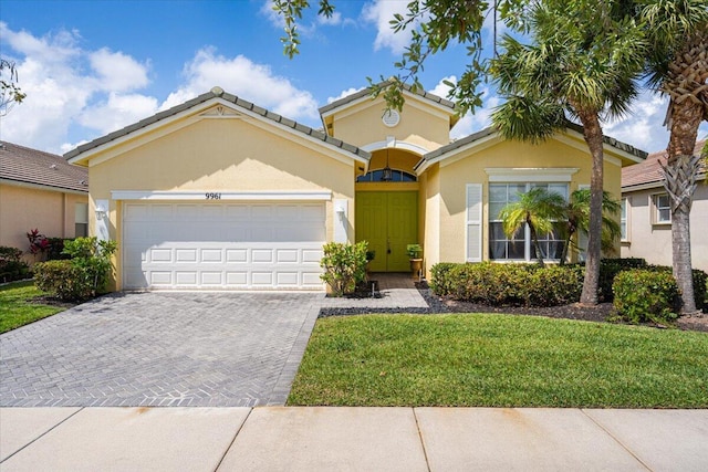 9961 SW Glenbrook Dr, Port Saint Lucie, FL 34987 - view of front of property featuring a tile roof, stucco siding, an attached garage, driveway, and a front yard