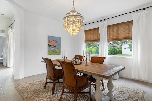 9961 SW Glenbrook Dr, Port Saint Lucie, FL 34987 - dining room featuring baseboards, visible vents, arched walkways, and light tile patterned floors