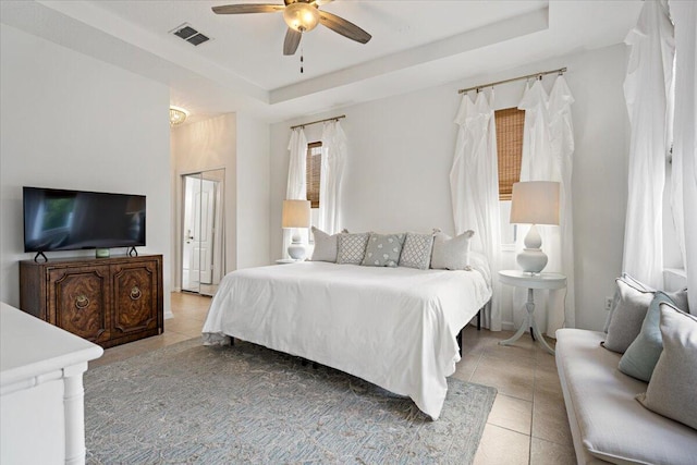 9961 SW Glenbrook Dr, Port Saint Lucie, FL 34987 - bedroom with light tile patterned flooring, a tray ceiling, visible vents, and a ceiling fan