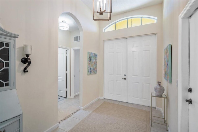9961 SW Glenbrook Dr, Port Saint Lucie, FL 34987 - tiled entryway with arched walkways, baseboards, a notable chandelier, and visible vents