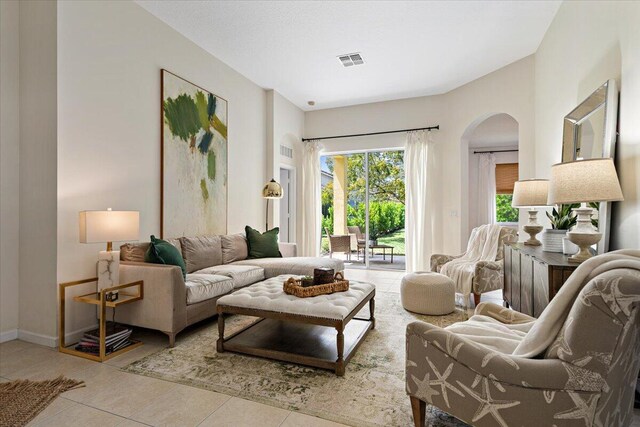 9961 SW Glenbrook Dr, Port Saint Lucie, FL 34987 - living area featuring arched walkways, baseboards, visible vents, and tile patterned flooring
