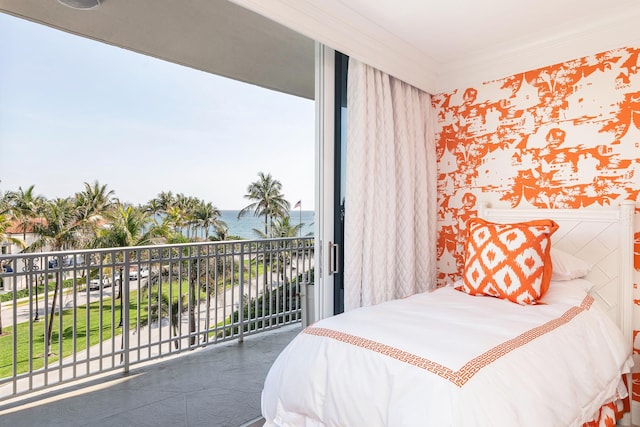 bedroom featuring a water view, ornamental molding, a wainscoted wall, and access to outside