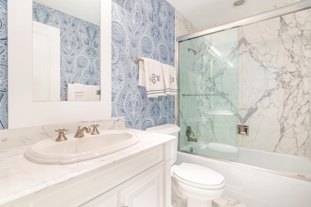 bathroom featuring toilet, vanity, enclosed tub / shower combo, and wallpapered walls