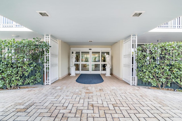 view of exterior entry featuring french doors and visible vents