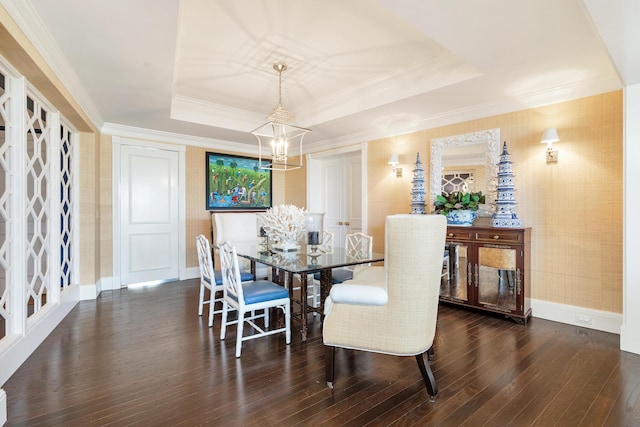 dining room with an inviting chandelier, a tray ceiling, ornamental molding, wood-type flooring, and baseboards