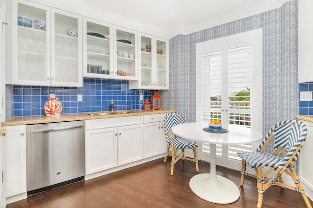 kitchen featuring ornamental molding, dishwasher, a sink, dark wood-style flooring, and wallpapered walls