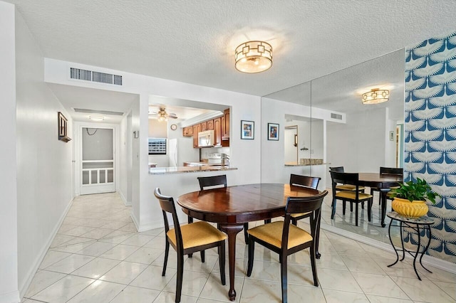 dining space with visible vents, a textured ceiling, and light tile patterned flooring