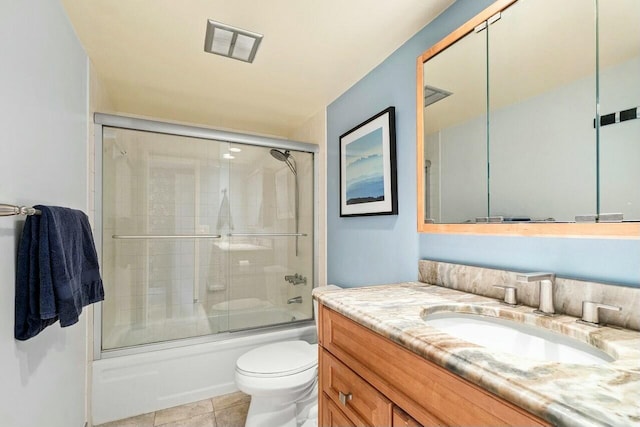 bathroom with toilet, visible vents, tile patterned flooring, combined bath / shower with glass door, and vanity