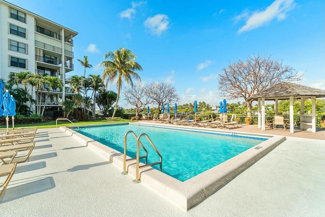 community pool with a gazebo and a patio