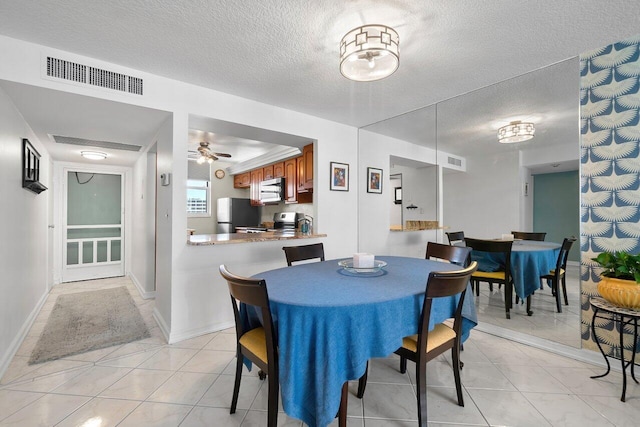 dining space featuring baseboards, visible vents, a textured ceiling, and ceiling fan