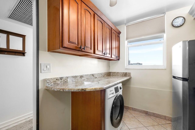 clothes washing area featuring light tile patterned floors, baseboards, and washer / clothes dryer