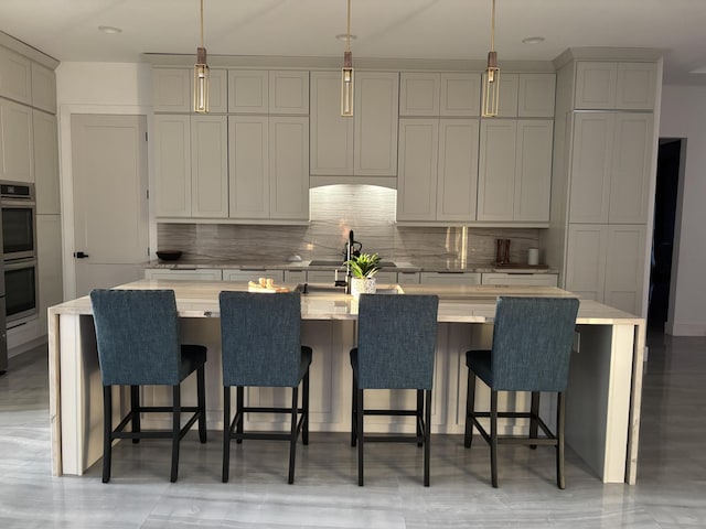 1071 S Header Canal Rd, Fort Pierce, FL 34945 - kitchen featuring backsplash, double oven, light countertops, a large island, and a kitchen bar