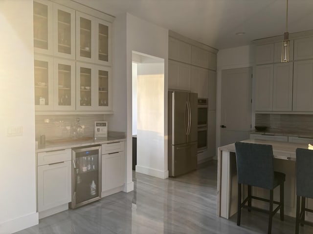 1071 S Header Canal Rd, Fort Pierce, FL 34945 - kitchen featuring stainless steel appliances, wine cooler, decorative backsplash, light countertops, and baseboards