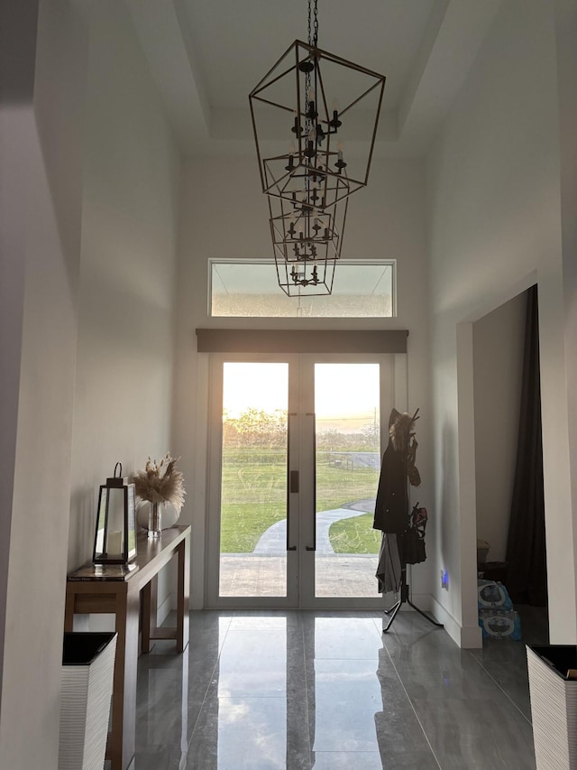 1071 S Header Canal Rd, Fort Pierce, FL 34945 - foyer with a towering ceiling, french doors, a chandelier, concrete floors, and baseboards