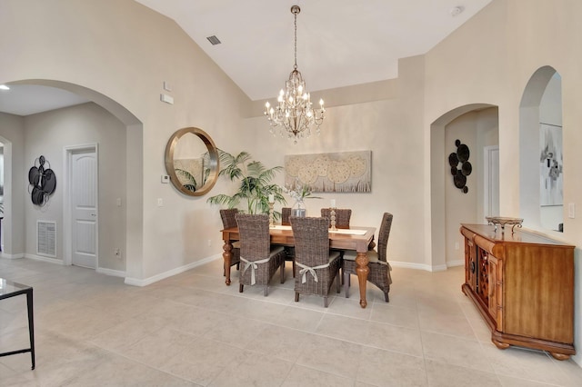 7147 Prudencia Dr, Lake Worth, FL 33463 - dining room with light tile patterned floors, a chandelier, arched walkways, high vaulted ceiling, and baseboards