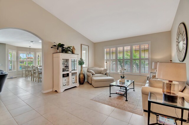 7147 Prudencia Dr, Lake Worth, FL 33463 - living room with arched walkways, baseboards, vaulted ceiling, and light tile patterned floors