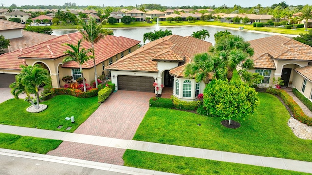 7147 Prudencia Dr, Lake Worth, FL 33463 - mediterranean / spanish-style house featuring a residential view, a garage, stucco siding, driveway, and a water view