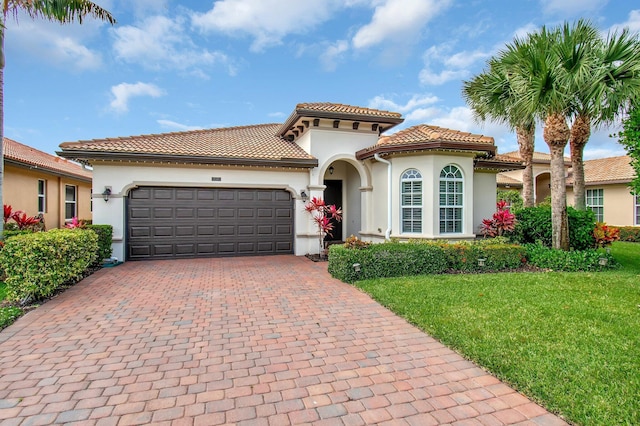 7147 Prudencia Dr, Lake Worth, FL 33463 - mediterranean / spanish house with stucco siding, decorative driveway, a front lawn, and an attached garage