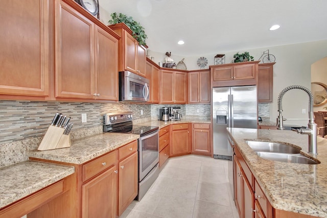 7147 Prudencia Dr, Lake Worth, FL 33463 - kitchen featuring stainless steel appliances, a sink, light stone counters, light tile patterned floors, and decorative backsplash