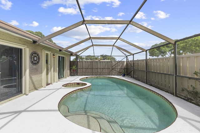 5652 Golden Eagle Cir, Palm Beach Gardens, FL 33418 - view of swimming pool with a fenced backyard, a pool with connected hot tub, glass enclosure, and a patio area