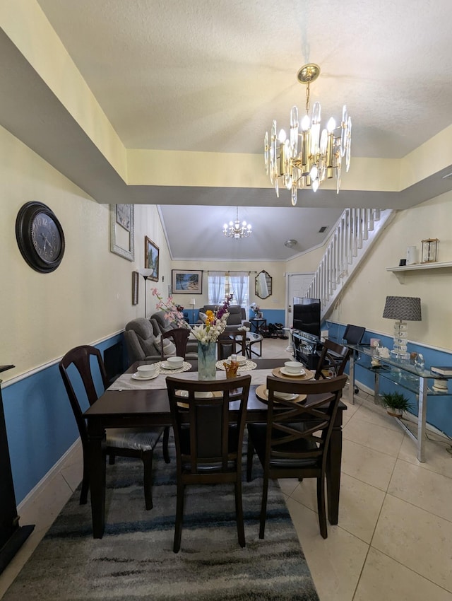 dining space with stairs, vaulted ceiling, tile patterned floors, baseboards, and an inviting chandelier