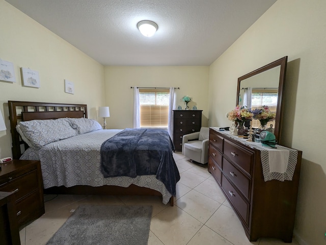 bedroom with a textured ceiling and light tile patterned floors
