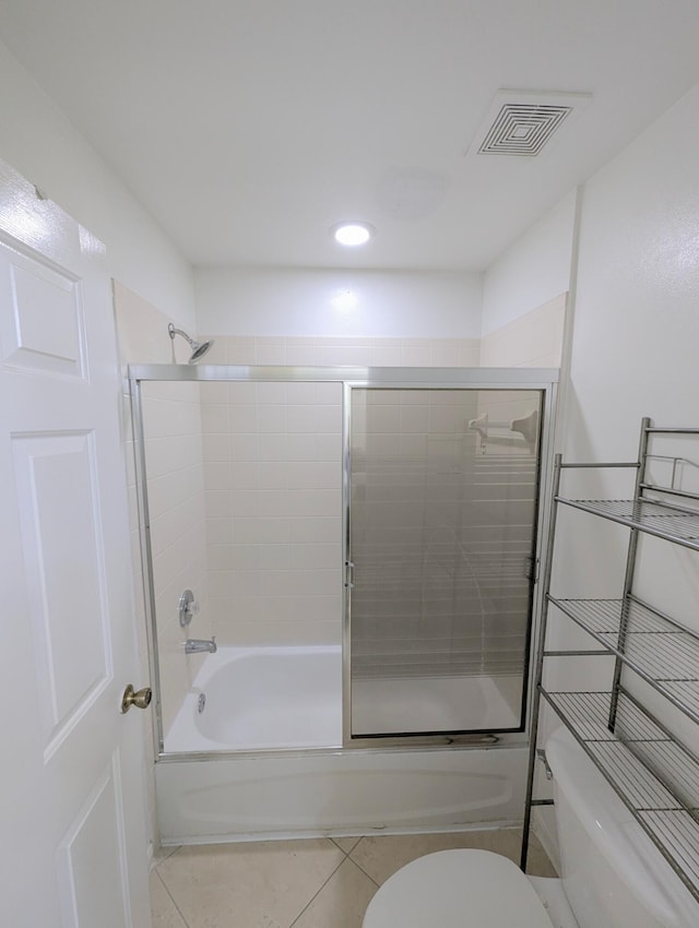 full bathroom featuring toilet, shower / bath combination with glass door, tile patterned flooring, and visible vents