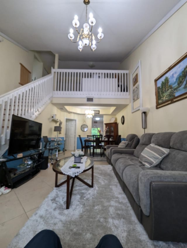 tiled living room with stairs, a towering ceiling, and an inviting chandelier