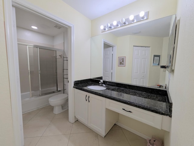 full bath with tile patterned flooring, vanity, shower / bath combination with glass door, and toilet