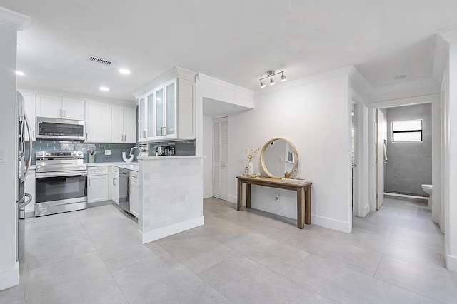 kitchen featuring decorative backsplash, light countertops, visible vents, white cabinets, and appliances with stainless steel finishes