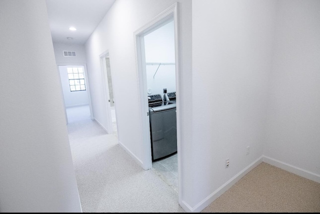 10403 Wellington Parc Dr, Wellington, FL 33449 - corridor with visible vents, baseboards, washing machine and dryer, and light colored carpet