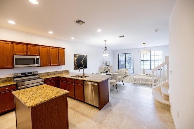 10403 Wellington Parc Dr, Wellington, FL 33449 - kitchen featuring a peninsula, light stone countertops, visible vents, stainless steel appliances, and a sink