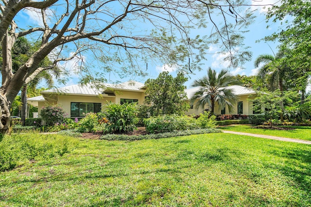 1125 NW 5th Ave, Delray Beach, FL 33444 - view of front facade with metal roof, stucco siding, a standing seam roof, and a front yard