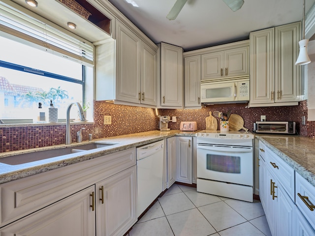 kitchen featuring a toaster, white appliances, light tile patterned flooring, decorative backsplash, and a sink