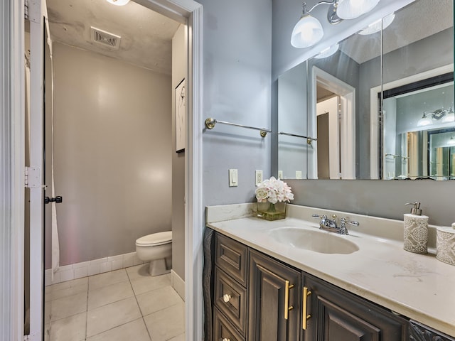 bathroom with vanity, visible vents, toilet, tile patterned floors, and baseboards