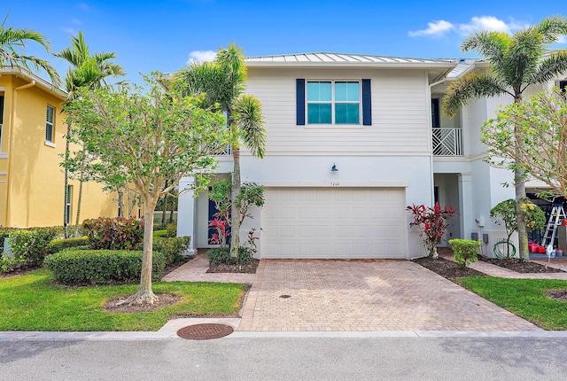 5264 Cambridge Ct, Palm Beach Gardens, FL 33418 - view of front facade featuring a standing seam roof, decorative driveway, a garage, metal roof, and stucco siding