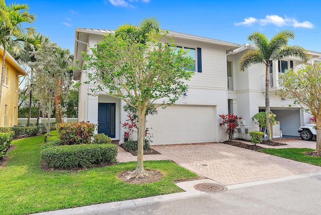 5264 Cambridge Ct, Palm Beach Gardens, FL 33418 - view of property featuring stucco siding, a garage, decorative driveway, and a front lawn