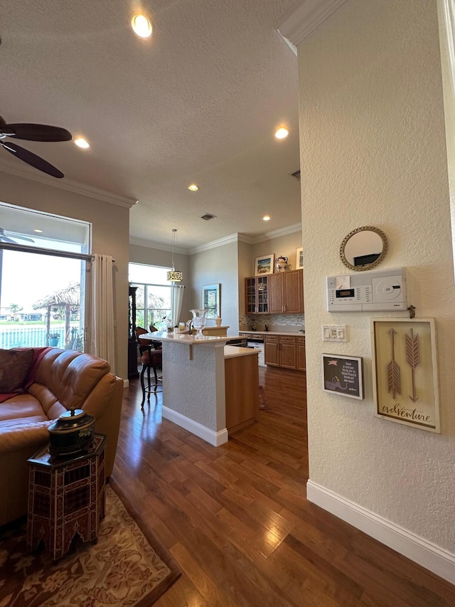 3112 Bollard Rd, West Palm Beach, FL 33411 - kitchen featuring ornamental molding, open floor plan, a kitchen island with sink, glass insert cabinets, and ceiling fan