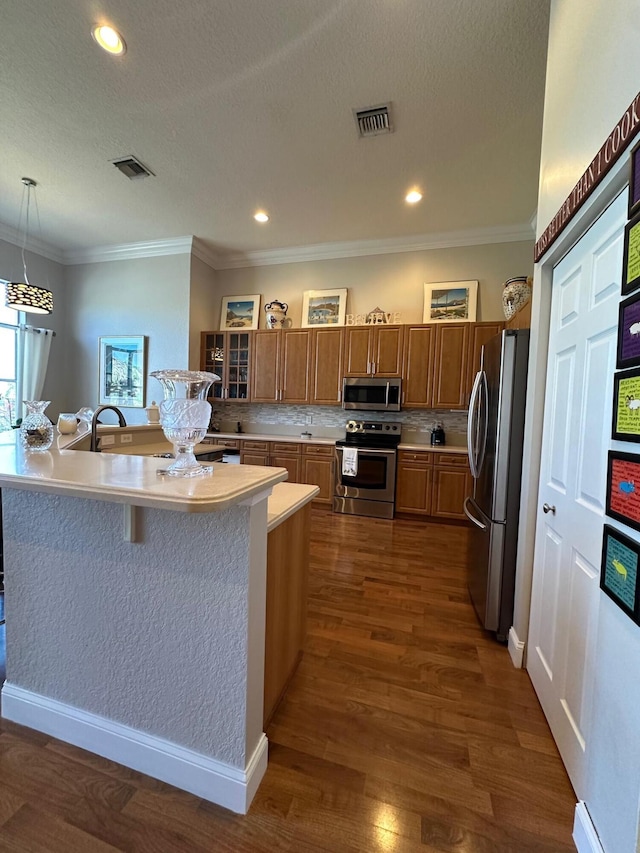 3112 Bollard Rd, West Palm Beach, FL 33411 - kitchen with stainless steel appliances, brown cabinets, light countertops, dark wood finished floors, and decorative light fixtures