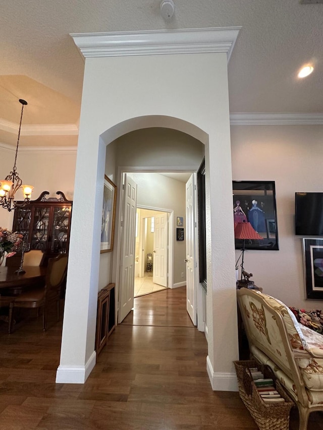 3112 Bollard Rd, West Palm Beach, FL 33411 - hall with arched walkways, crown molding, wood finished floors, a chandelier, and baseboards