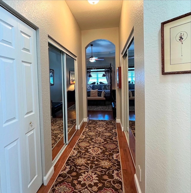 3112 Bollard Rd, West Palm Beach, FL 33411 - hall featuring a textured wall, wood finished floors, and arched walkways