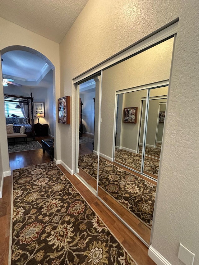 3112 Bollard Rd, West Palm Beach, FL 33411 - hall with hardwood / wood-style floors, arched walkways, and a textured wall