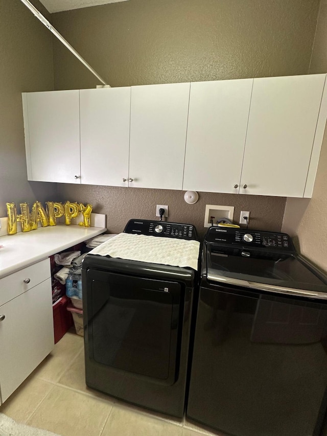 3112 Bollard Rd, West Palm Beach, FL 33411 - laundry room with cabinet space, washer and dryer, a textured wall, and light tile patterned floors