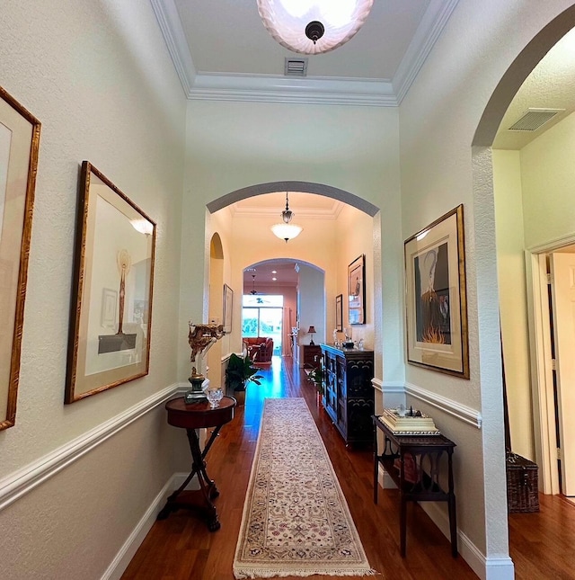 3112 Bollard Rd, West Palm Beach, FL 33411 - corridor with dark wood finished floors, crown molding, arched walkways, and baseboards