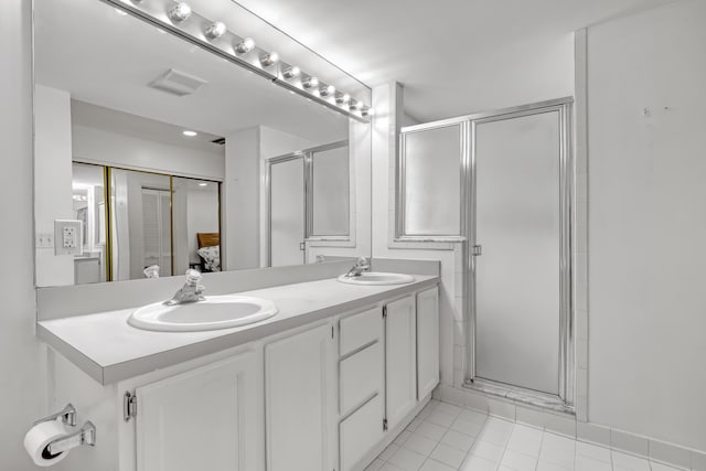bathroom with visible vents, a sink, and a stall shower