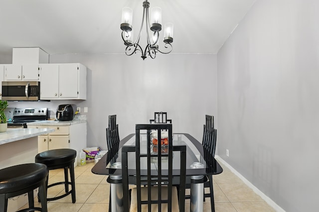dining area with baseboards, an inviting chandelier, and light tile patterned floors