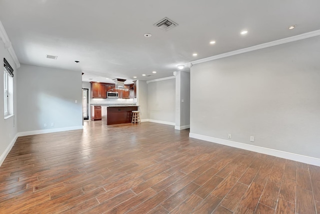 unfurnished living room with baseboards, visible vents, recessed lighting, and crown molding