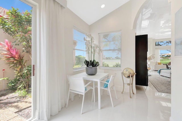 dining space featuring plenty of natural light, baseboards, vaulted ceiling, and tile patterned flooring